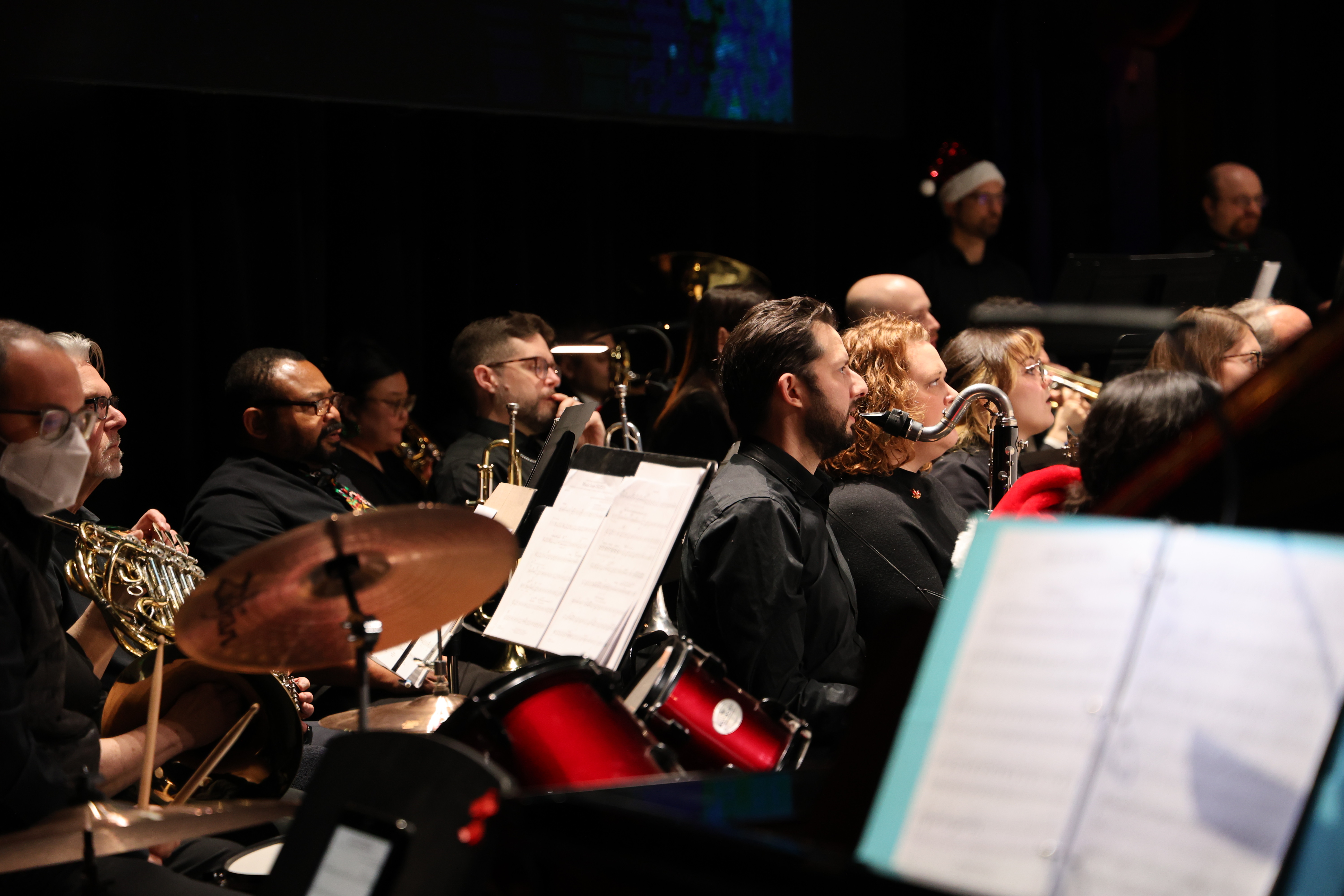 Photograph of an orchestra playing instruments in concert.